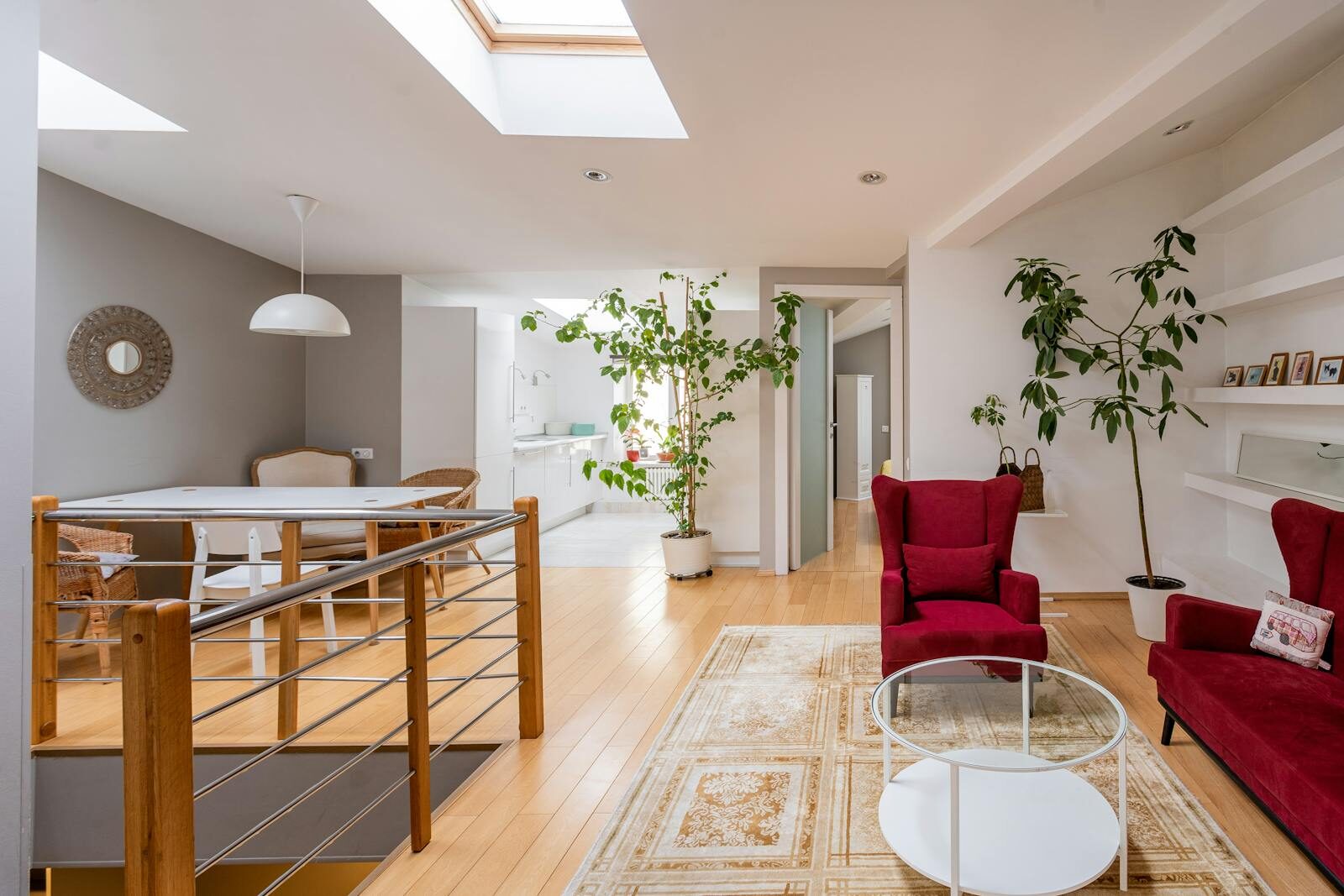 A bright, contemporary living room featuring red armchairs and minimalist design elements.